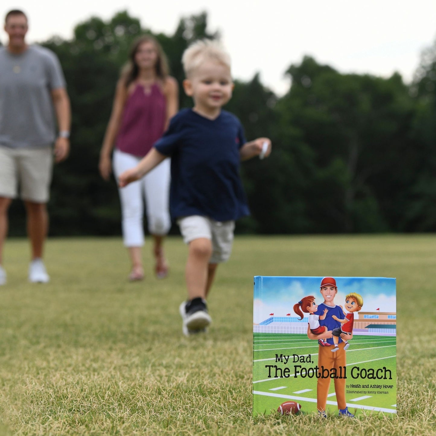 boy running up to book and parents following behind