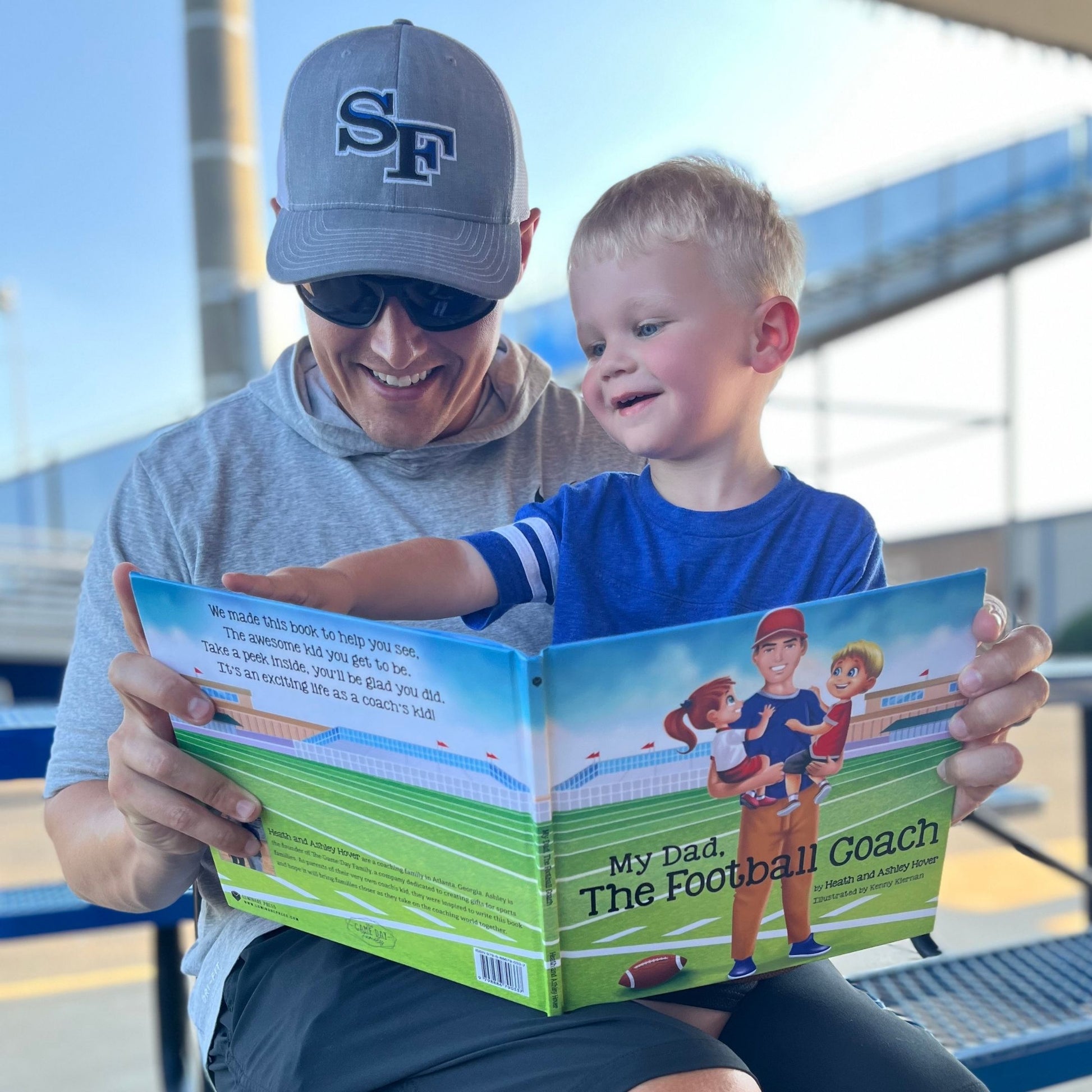football coach and son reading football book at the football field